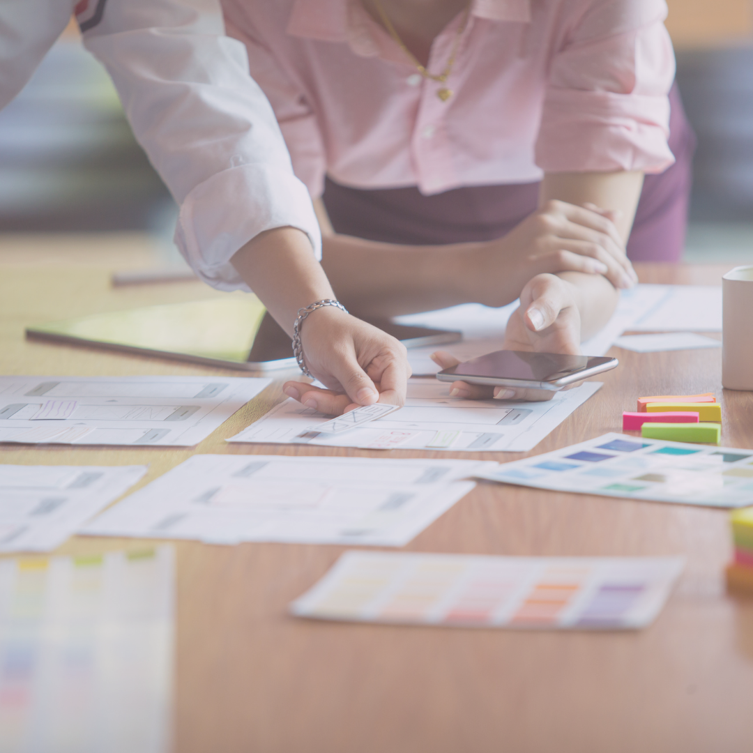 People gathered over papers, reviewing colour swatches