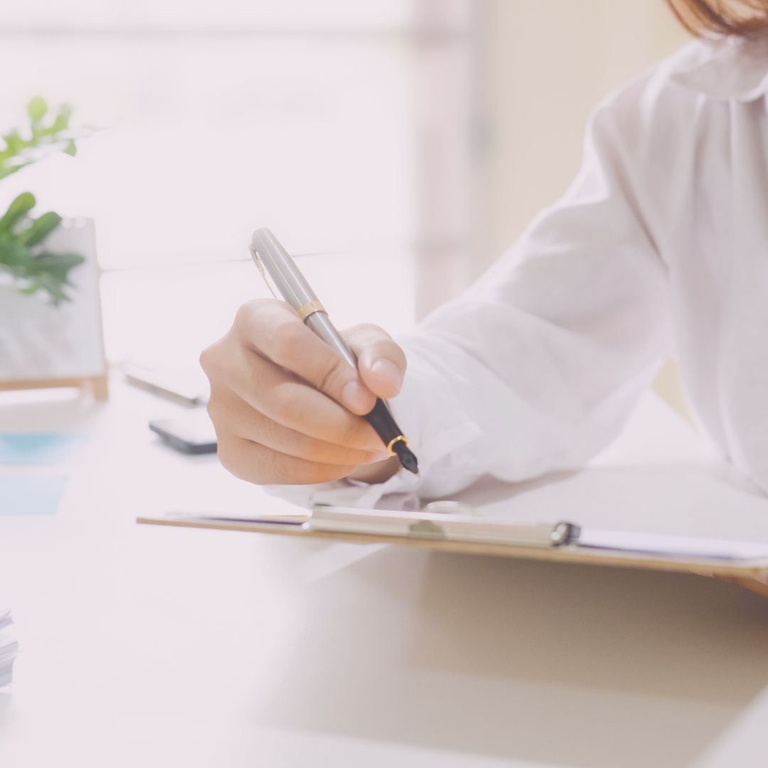 Close-up of a hand holding a pen writing in a notebook