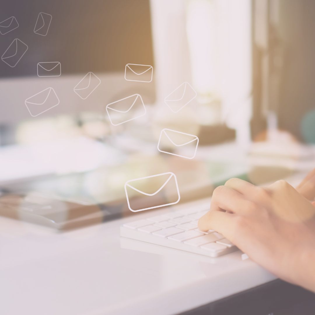 Close-up of hands typing on a keyboard with email icons appearing above the keys