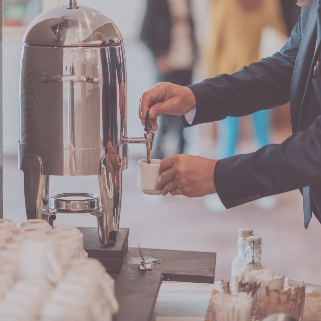 Someone pouring coffee from a coffee urn at a conference