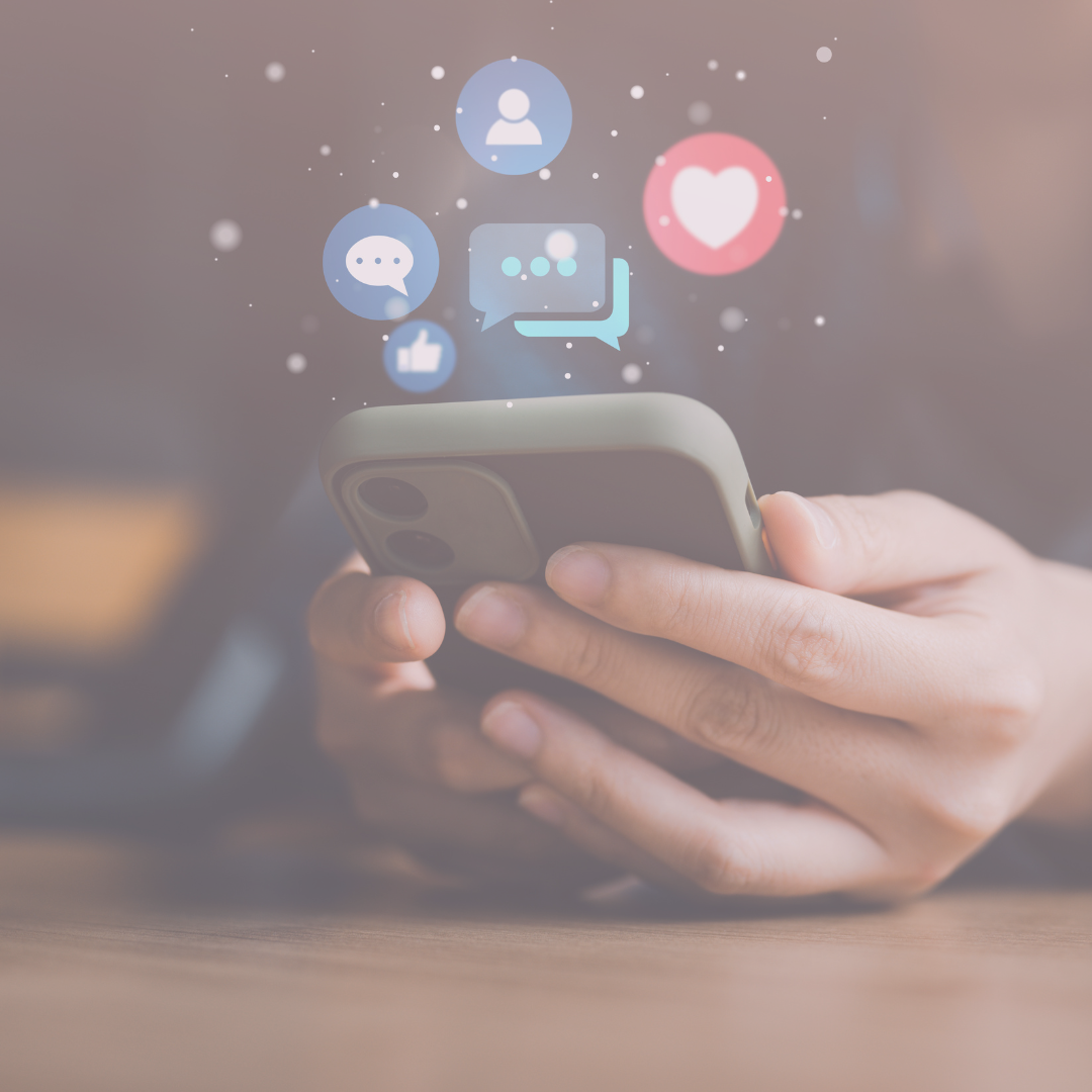 Close-up of hands holding a phone with social media icons appearing above the screen